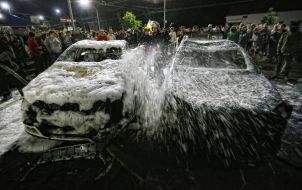 Firefighter pours foam overturned cars