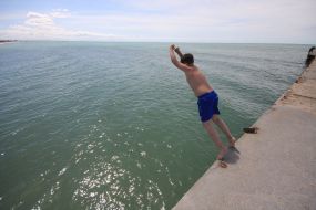 Мальчик прыгает с пирса