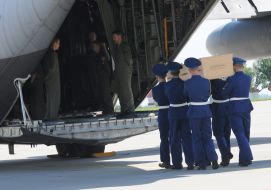 The soldiers loaded the coffin into the plane