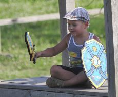 Boy holding a symbolic sword and shield