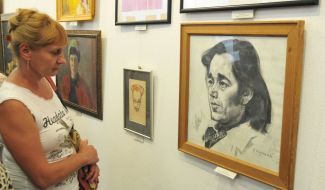 Visitors look at paintings in the exhibition "Flash"