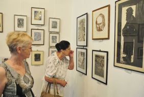 Visitors look at paintings in the exhibition "Flash"