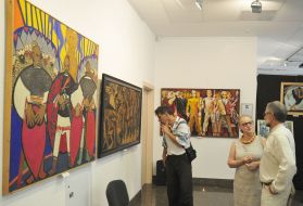 Visitors look at paintings in the exhibition "Flash"