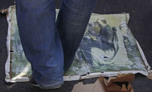 Activist trampling a poster of Lenin