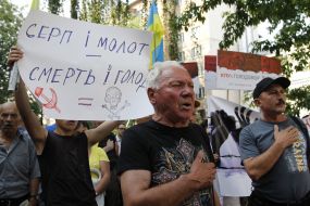 Protesters hold a poster