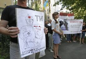 Protesters hold a poster