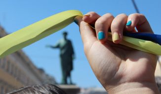 A girl holds a yellow and blue ribbon in the hands