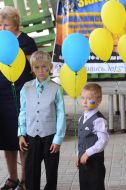 A boy holding yellow and blue balloons