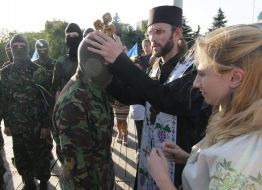 A priest blesses the volunteers