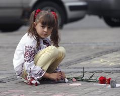 The girl draws a chalk on asphalt