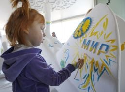 Девочка разрисовывает статую голубя