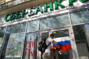 Активисты рисуют на витрине банка флаг РФ