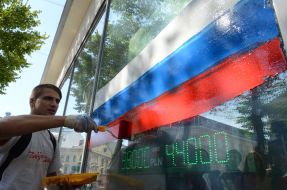 Активисты рисуют на витрине банка флаг РФ