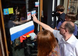 Активисты рисуют на витрине банка флаг РФ