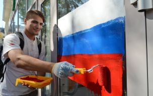 Активисты рисуют на витрине банка флаг РФ