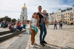 Mother with children during the parade of Sling