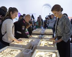 Marina Poroshenko considers drawing in the sand