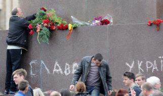 Supporters of the Communist Party laying flowers on the empty pedestal
