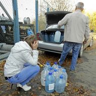 People collect water in plastic containers