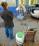 People collect water in plastic containers