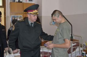 Victor Muzhenko talks to soldiers in the hospital