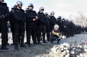 A pile of paving stones at police officers