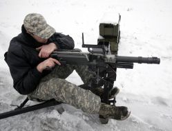Soldier demonstrates automatic grenade launcher UAG-40