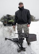 Soldier demonstrates automatic grenade launcher UAG-40