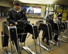 People pass through the turnstiles in the subway
