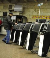 People pass through the turnstiles in the subway