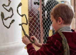 Мальчик плетет маскировочную сетку