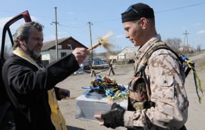 The priest sprinkles holy water on the soldiers