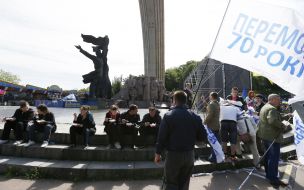 Участники праздничного митинга едят гречневую кашу