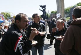 Участники праздничного митинга едят гречневую кашу