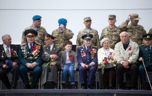 The boy sits near veterans