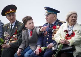 The boy sits near veterans