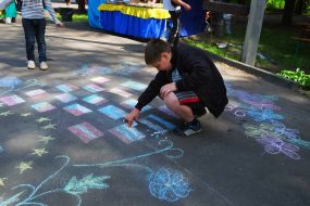 Мальчик рисует на асфальте