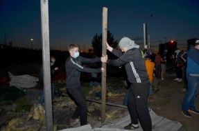 Люди ломают забор