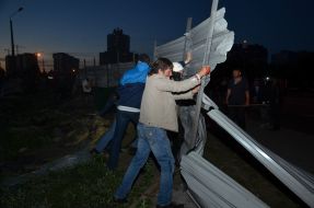 Люди ломают забор