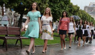 Catwalk models in embroidered shirts and dresses