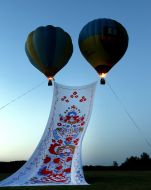 Balloons rise giant towel in the sky