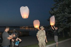 Люди запускают в небо воздушные фонарики