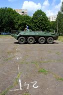 A boy sits on an armored personnel carrier