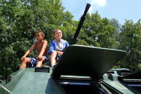 A boy sits on an armored personnel carrier