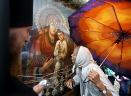 Верующая возле чудотворной иконы Божией Матери