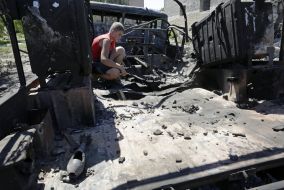 Мальчик рассматривает сгоревший склад боеприпасов