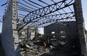 Мальчик рассматривает сгоревший склад боеприпасов