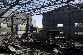 Мальчик рассматривает сгоревший склад боеприпасов