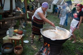 Жінка готує величезний казан борщу