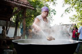 A woman prepares a huge pot of borscht
